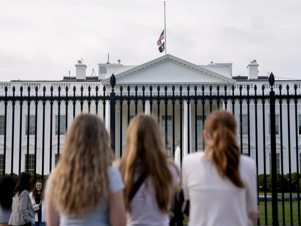 Visitors look upon the White House as the U.S. flag flies at half mast following a school shooting in Nashville, Tenn., last March.