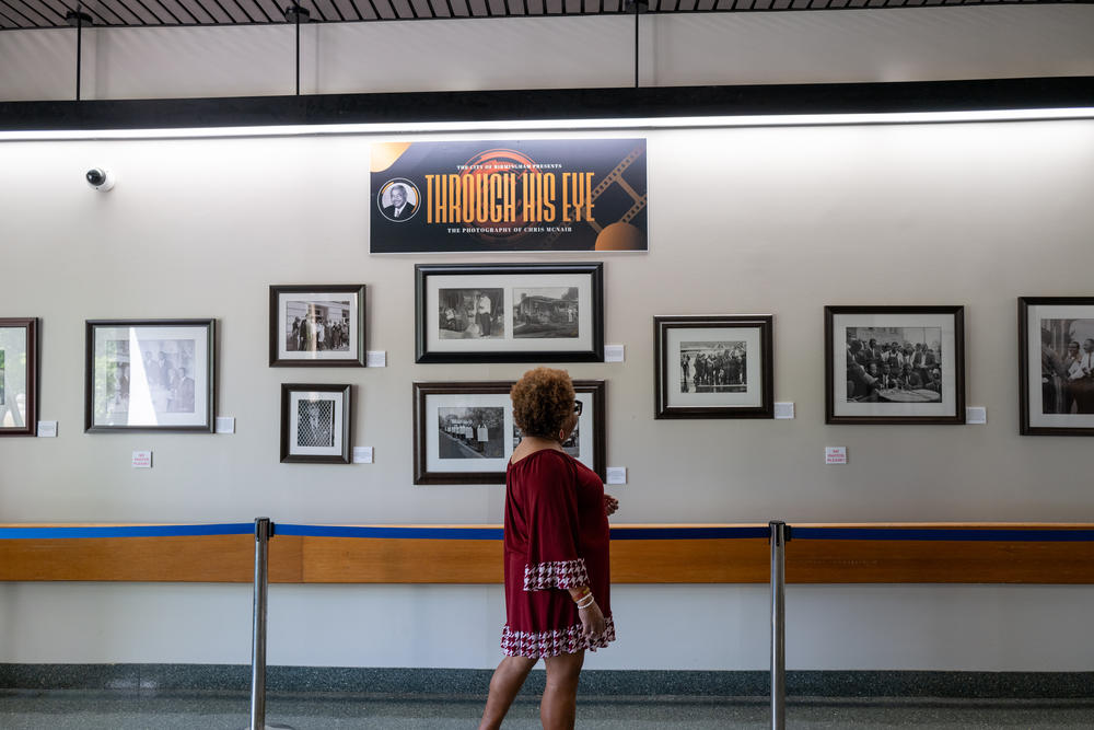 Lisa McNair walks through an exhibit of photographs made by her late father, Chris McNair.