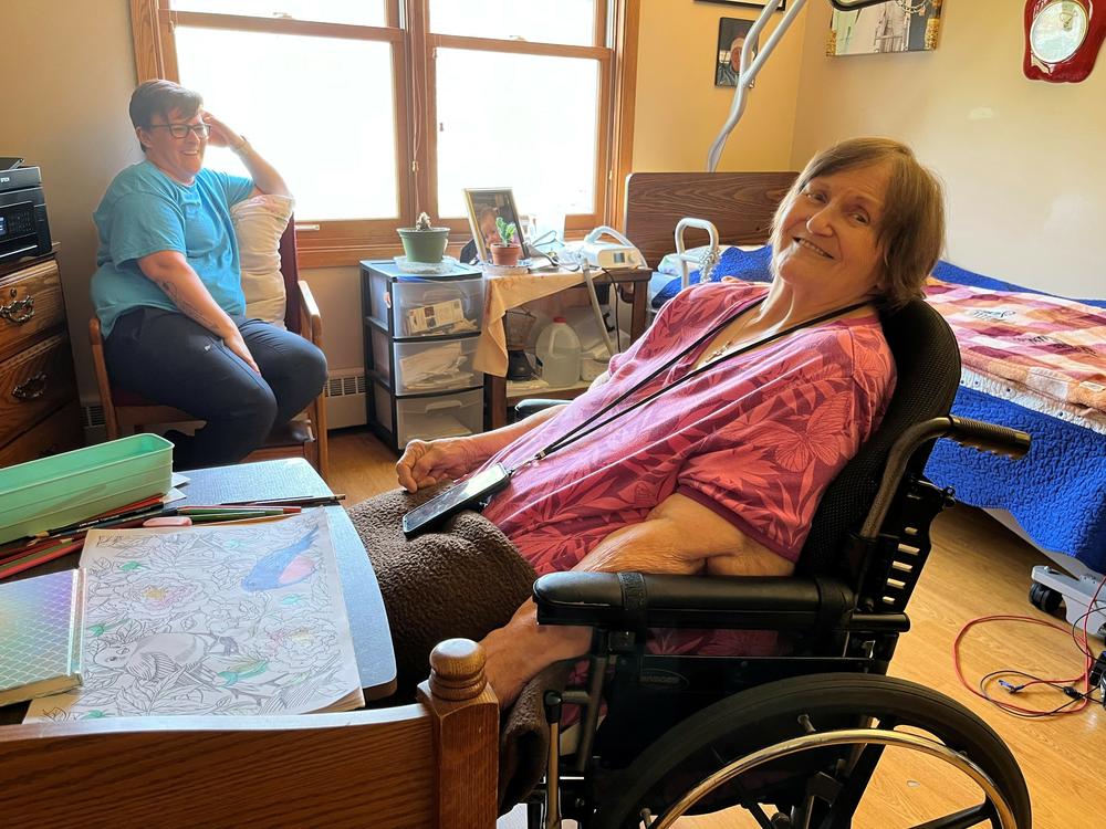 Nellie Swale, a resident of Good Samaritan in Syracuse, Nebraska, hangs out with Karena Cunningham, a certified nursing assistant, who says her clients and colleagues are family to her.