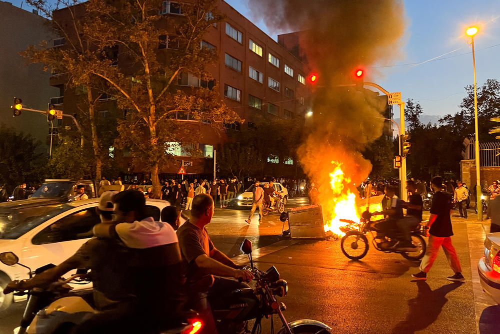 A police motorcycle burns during a protest over the death of Mahsa Amini, a woman who died after being arrested by the Iranian morality police, in Tehran, Sept. 19, 2022.