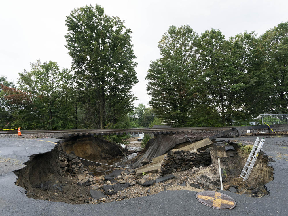 The ground under train tracks in Leominster, Mass., was washed out by flooding, as seen Wednesday. The town northwest of Boston is one of many communities suffering from heavy storms this summer.