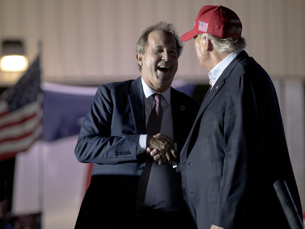 Former President Donald Trump (right) shakes hands with Texas Attorney General Ken Paxton at an October 2022 rally in Robstown, Texas.