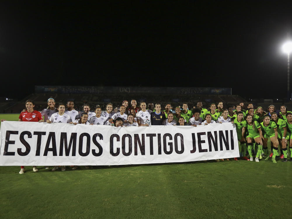 Players with Hermoso's club team, Pachuca, hold a banner reading in Spanish 