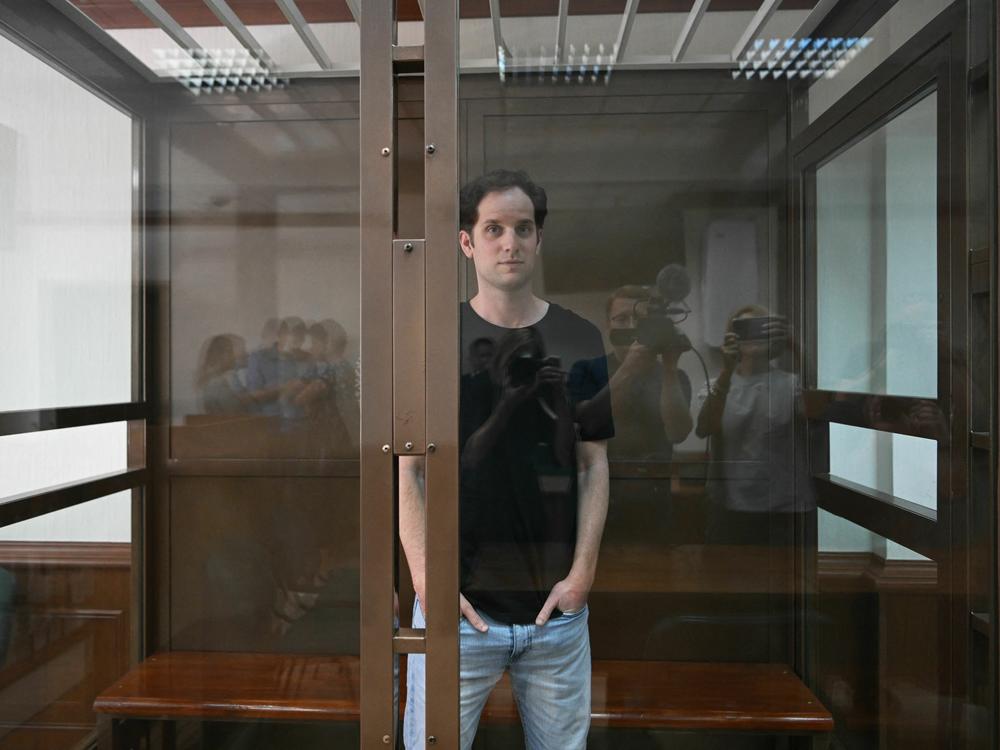 Evan Gershkovich stands inside a defendants' cage before a June hearing in Moscow.