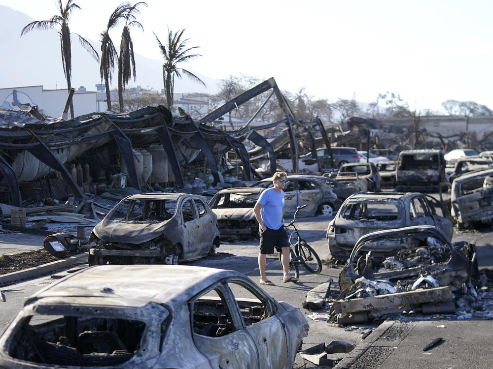 A man walks through wildfire wreckage Aug. 11, in Lahaina, Hawaii.