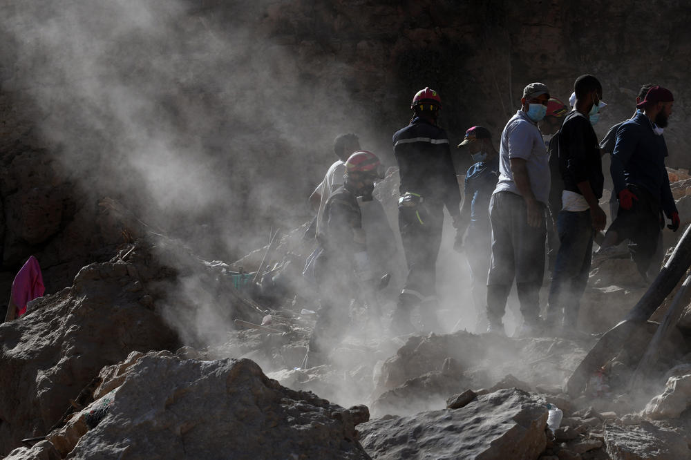 Rescue teams and civil protection members search the rubble for bodies.