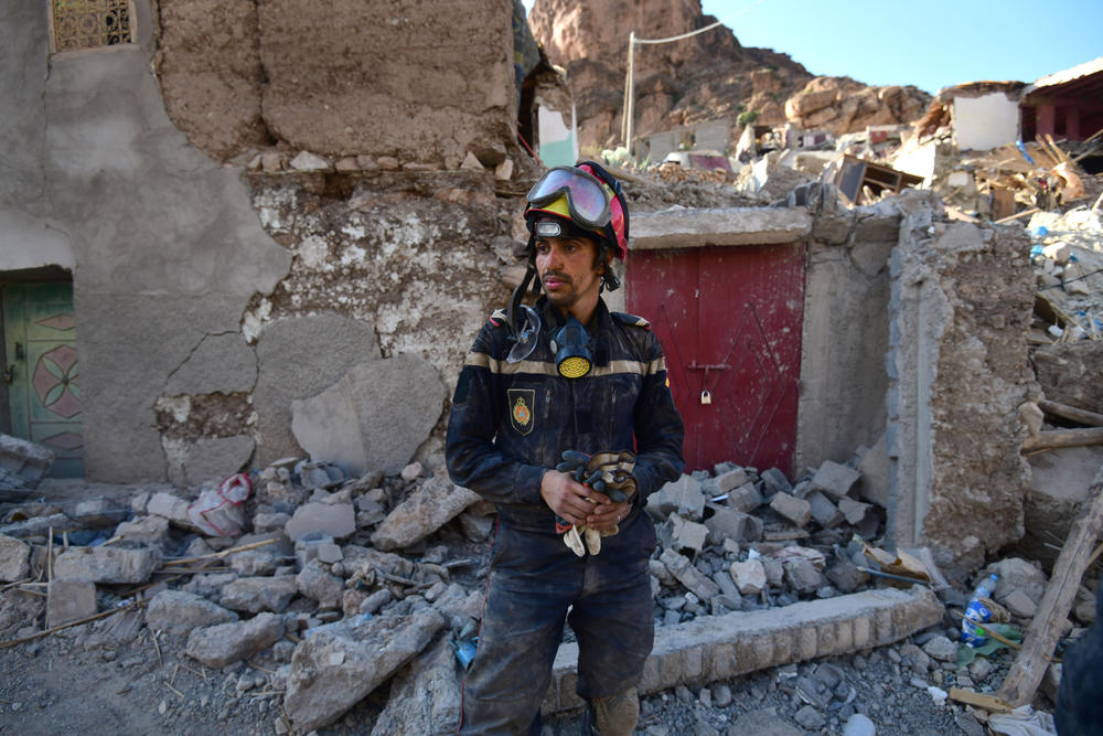 A member of the Moroccan civil protection takes a break after hours of digging under the hot sun to try to recover the bodies of earthquake victims in Imi N'Tala, Morocco, on Sept. 13.