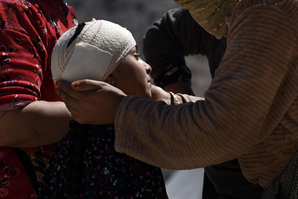 Walking wounded residents wait as rescue teams and civil protection members search the rubble for bodies in Imi N'Tala, Morocco, on Sept. 13.