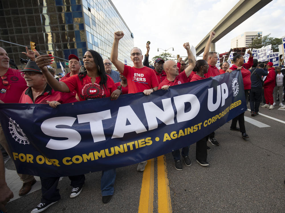 United Auto Workers President Shawn Fain marches with UAW members through downtown Detroit on Friday after a rally in support of UAW members as they strike against the automakers Ford, General Motors and Stellantis.