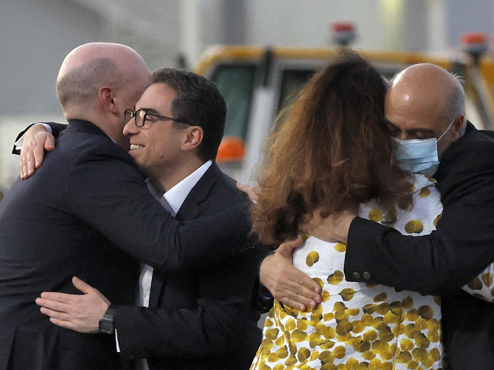 Siamak Namazi (second left) and Morad Tahbaz (right) are welcomed after disembarking from a Qatari jet on their arrival at the Doha International Airport on Monday.