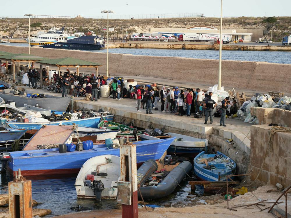 Migrants wait at the port after arriving on the Italian island of Lampedusa, on Monday, Sept. 18, 2023. Italy unveiled tough rules to deter migrants after record boat crossings from North Africa to Lampedusa saw the country's southernmost tip overwhelmed with new arrivals.