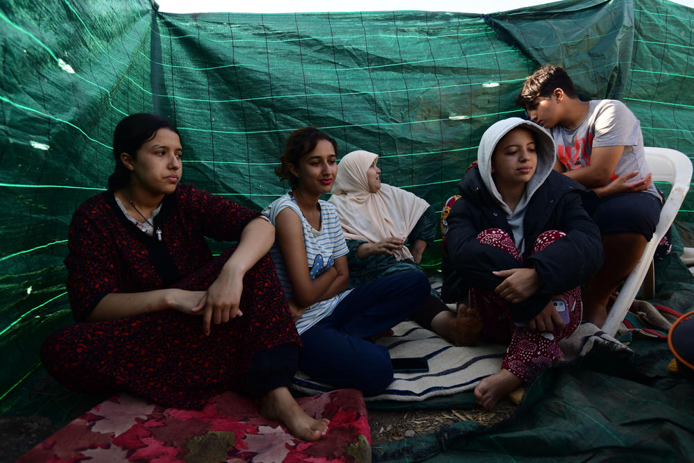 Erbeen and her family gather in an enclosed space on her grandfather's land, where they have been sleeping since the quake hit.