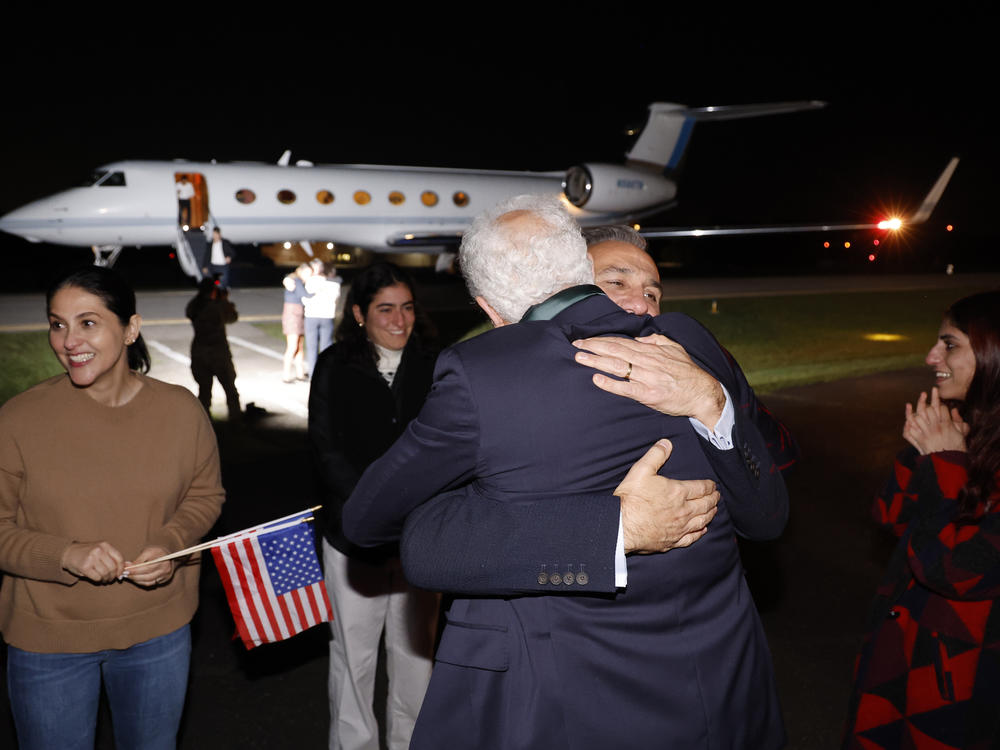 Family members embrace freed Americans Siamak Namazi, Morad Tahbaz and Emad Shargi, as well as two returnees whose names have not been released by the U.S. government, who were released in a prisoner swap deal between U.S and Iran, as they arrive at Davison Army Airfield on Tuesday at Fort Belvoir, Va.
