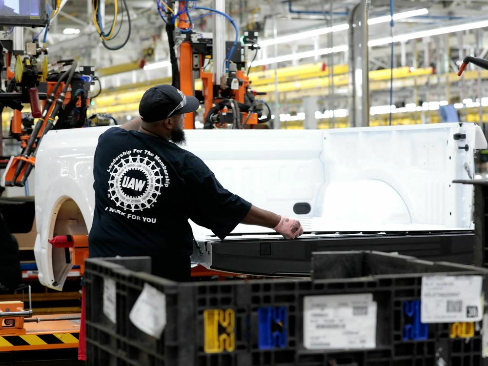 A worker on a Ford F-150 Lightning truck under production at the automaker's Rouge Electric Vehicle Center in Dearborn, Mich., on Sept. 20, 2022. Automakers argue they can't meet the UAW contract demands because it would make them too uncompetitive, especially as they transition to electric vehicles.