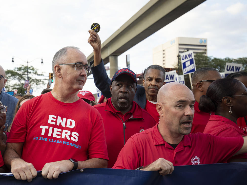 UAW President Shawn Fain marches with UAW members through downtown Detroit as the union strikes against the Big Three auto makers on Sept. 15, 2023. Currently new workers are being paid less than veteran employees, creating a tiered system that the UAW would like to end.