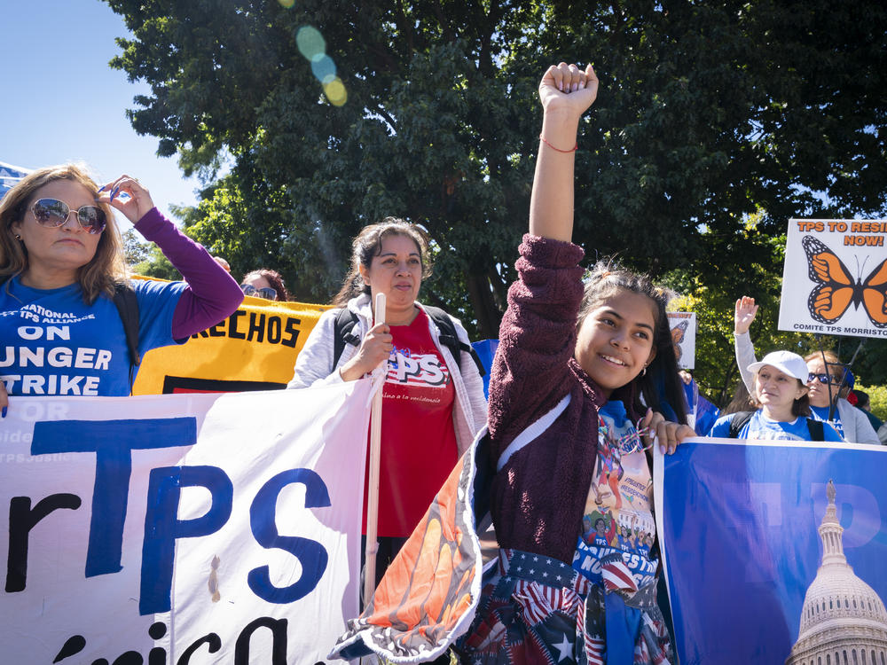 Marilyn Miranda, 12, of Washington raises her hand up during a protest for an extension of the Temporary Protected Status in September 2022 in Washington, D.C.