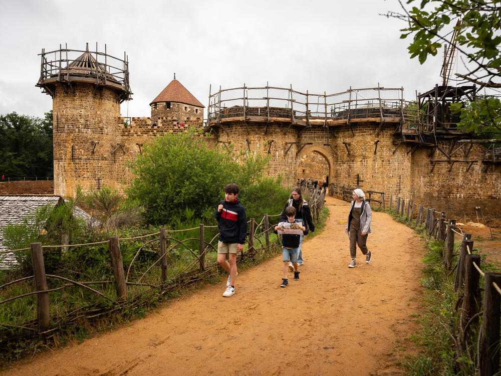 Visitors walk near the construction of Guédelon Castle, dreamed up as an exercise in 