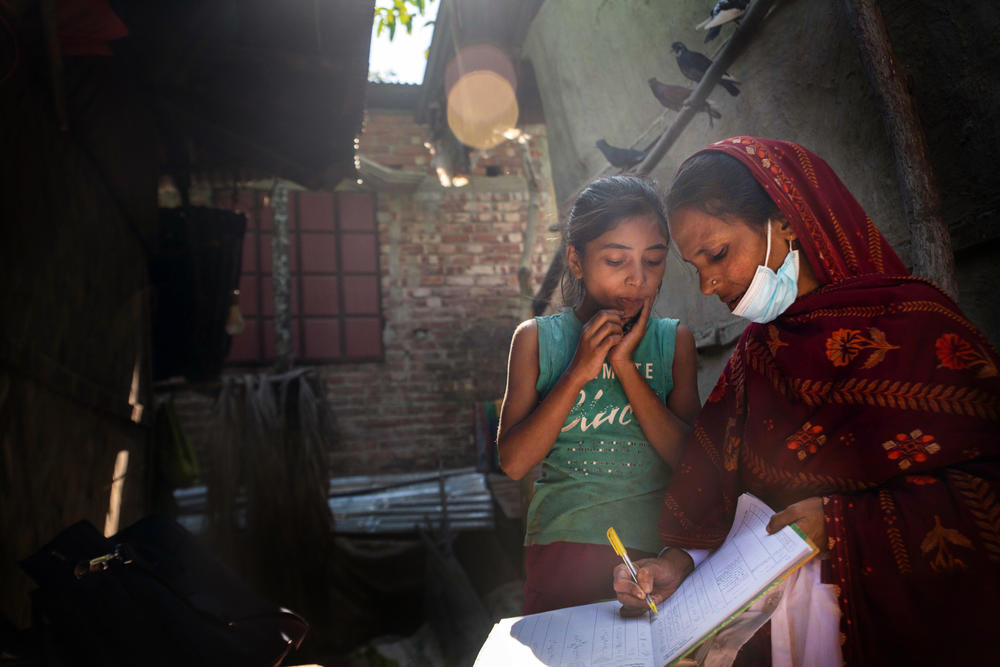 Community health worker Bulbul Aktar handwrites her notes to keep track of the spread of malaria.