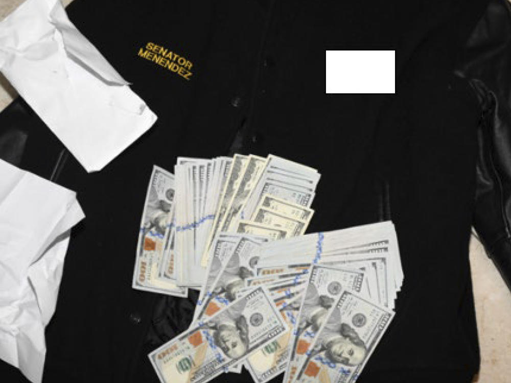 This photo, which was included in an indictment of U.S. Sen. Bob Menendez, D-N.J., shows a jacket bearing Menendez's name, along with cash from envelops found inside the jacket during a search by federal agents of the senator's home in Harrison, N.J., in 2022.