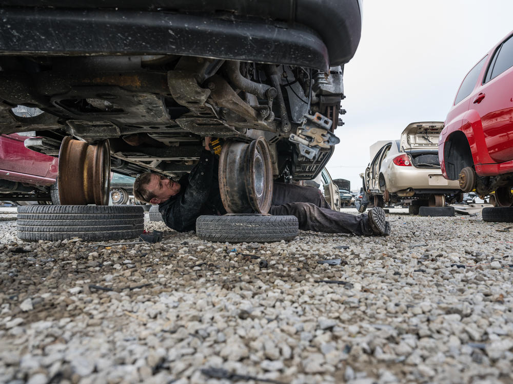 Tony Hanes, a self-employed mechanic, works to pick used car parts from a salvage automobile at Pull-A-Part in Louisville, Kentucky, on Jan. 13, 2022. The UAW is expanding its strike against GM and Stellantis, targeting their
