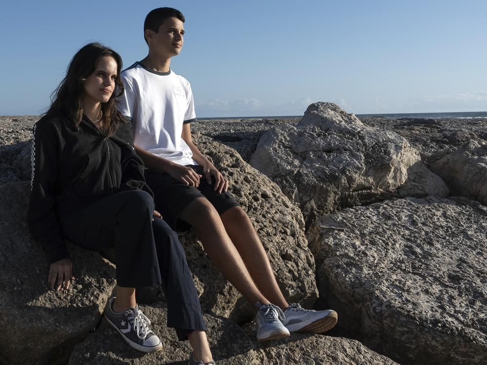 Siblings Sofia Oliveira, 18, and Andre Oliveira, 15, pose for a picture at the beach in Costa da Caparica, south of Lisbon, Wednesday, Sept. 20, 2023.