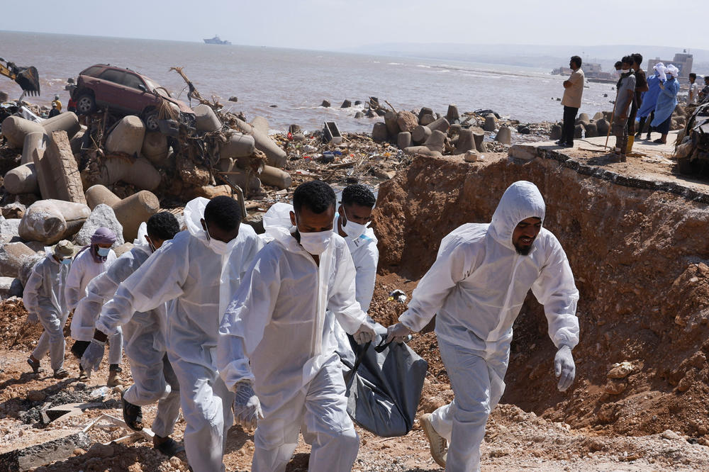 Volunteer Hossam Almegassabe and others carry a body recovered after being swept out to the sea during floods in Derna, Sept. 16.