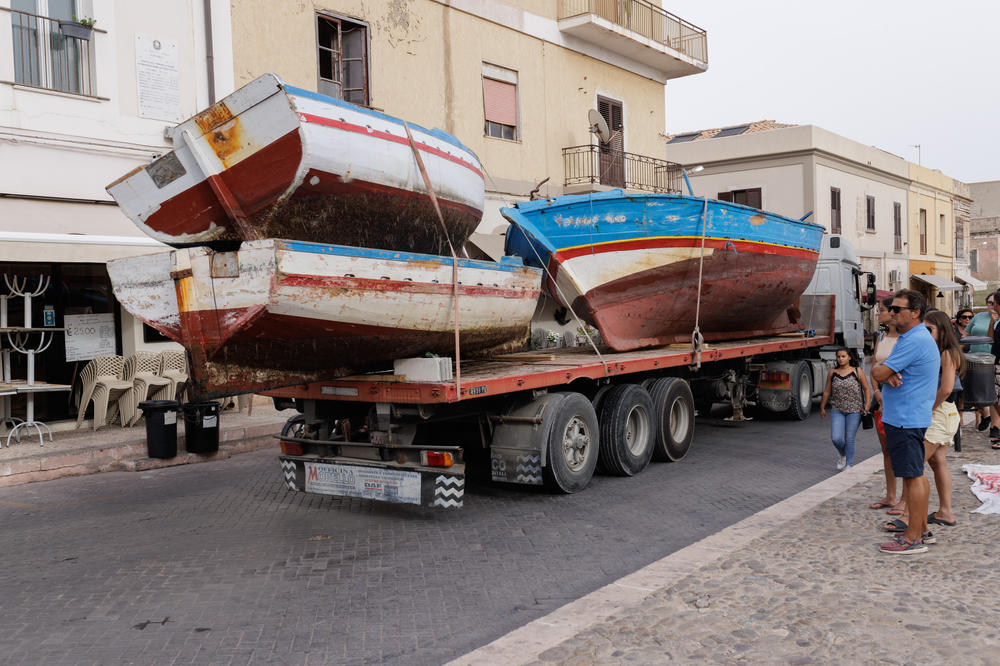 Boats used by migrants to arrive at Lampedusa are transported to the port, Sept. 20.