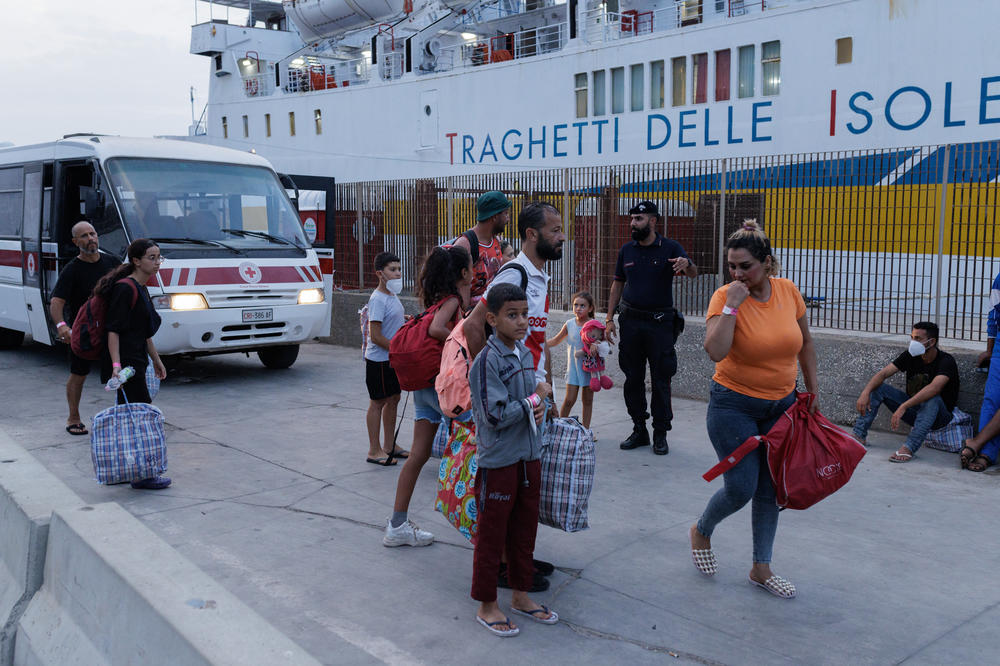 Migrants in Lampedusa's Porto Vecchio wait to be transferred by ferry to Porto Empedocle, from where they will be sent to reception centers across the country, Sept. 20.