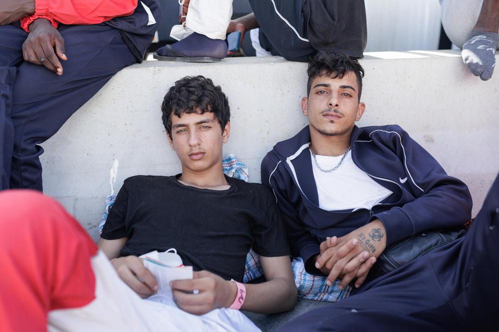 Two Syrian migrants wait to be transferred to Sicily by ferry in Lampedusa, Sept.22.