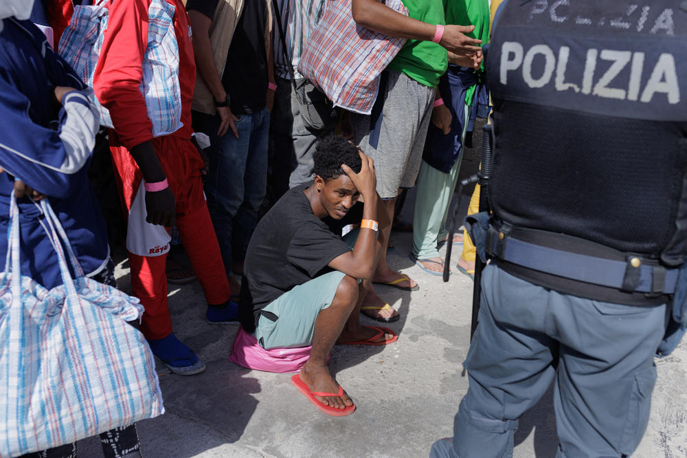 Migrants in Lampedusa's Porto Vecchio wait to be transferred by ferry to Porto Empedocle and then sent to reception centers, Sept. 22.