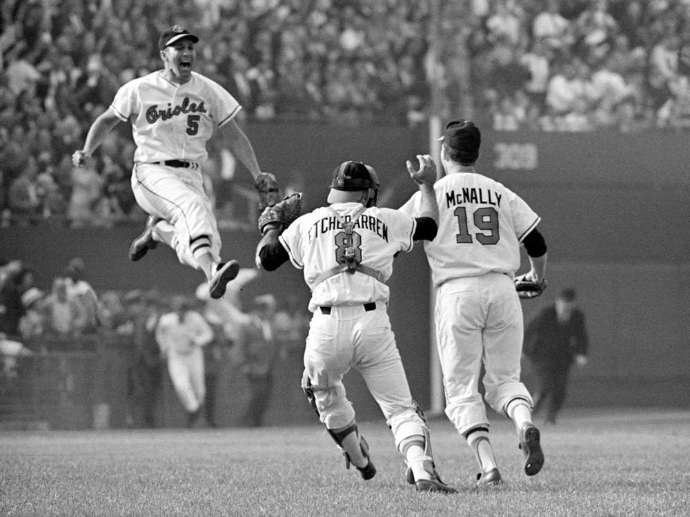 Baltimore Orioles third baseman Brooks Robinson (5) leaps across the infield to congratulate pitcher Dave McNally (19) and Orioles catcher Andy Etchebarren (8) after the final out in a World Series baseball game against the Los Angeles Dodgers in Baltimore, Md., on Oct. 9, 1966.