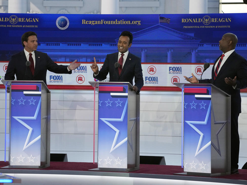 From left to right, Florida Gov. Ron DeSantis, businessman Vivek Ramaswamy and Sen. Tim Scott, R-S.C., argue a point during a Republican presidential primary debate hosted by FOX Business Network and Univision on Wednesday.