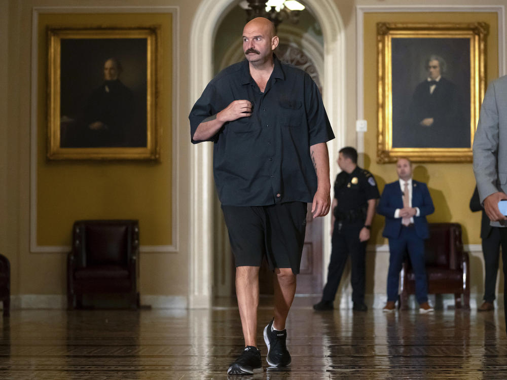 Sen. John Fetterman, D-Pa., walks on Capitol Hill on Thursday. He says he will continue to wear a suit on the Senate floor in compliance with the newly codified dress code.
