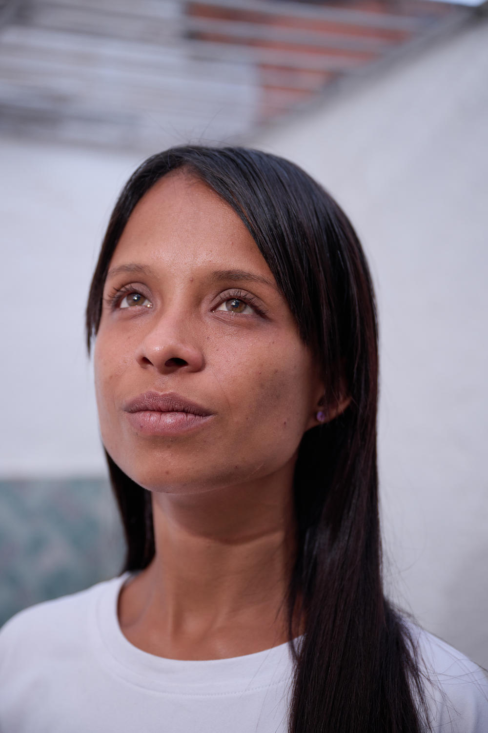 Livia Gonzalez poses for a portrait on the terrace of Casa in Medellín. Livia has been traveling to and from Colombia for the past few years working odd jobs to send back to her family in Caracas.