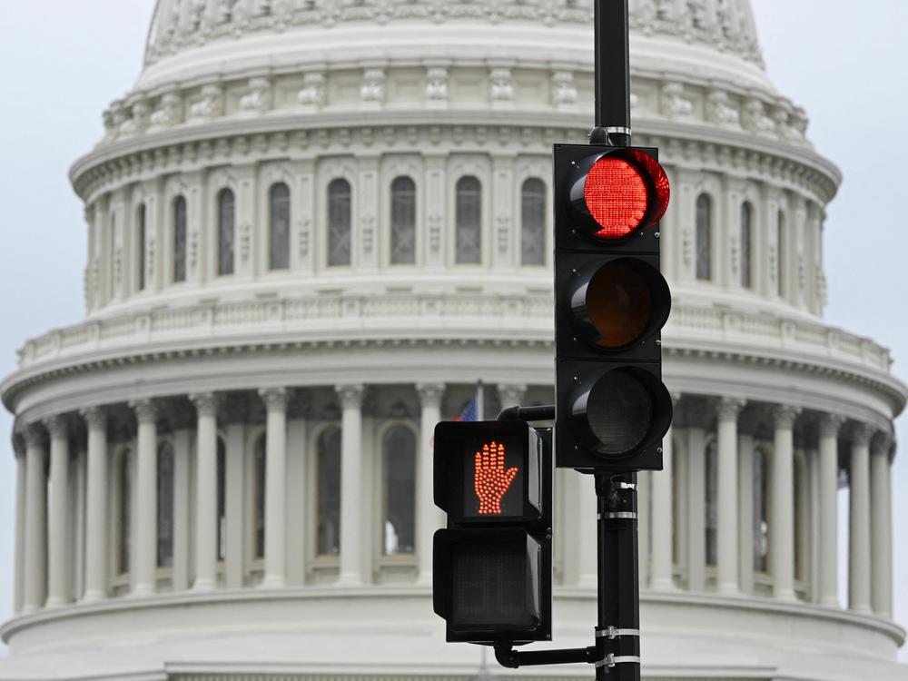 A stoplight is seen in front of the dome of the U.S. Capitol in Washington, D.C., on Thursday. The government has begun to inform workers of an impending shutdown that could see millions of federal employees and military personnel sent home or working without pay.