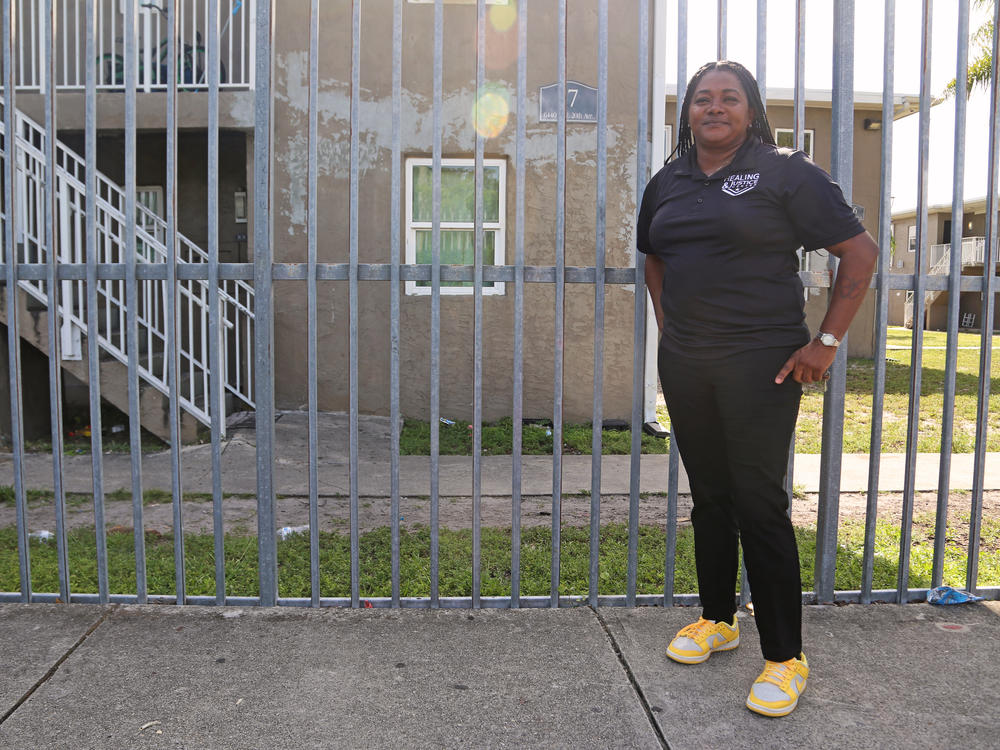 Peacemaker Olivia Eason stands outside of the Lincoln Fields apartments in Miami, Fla., where she visits regularly to help connect residents with resources and diffuse tension when there's conflict.