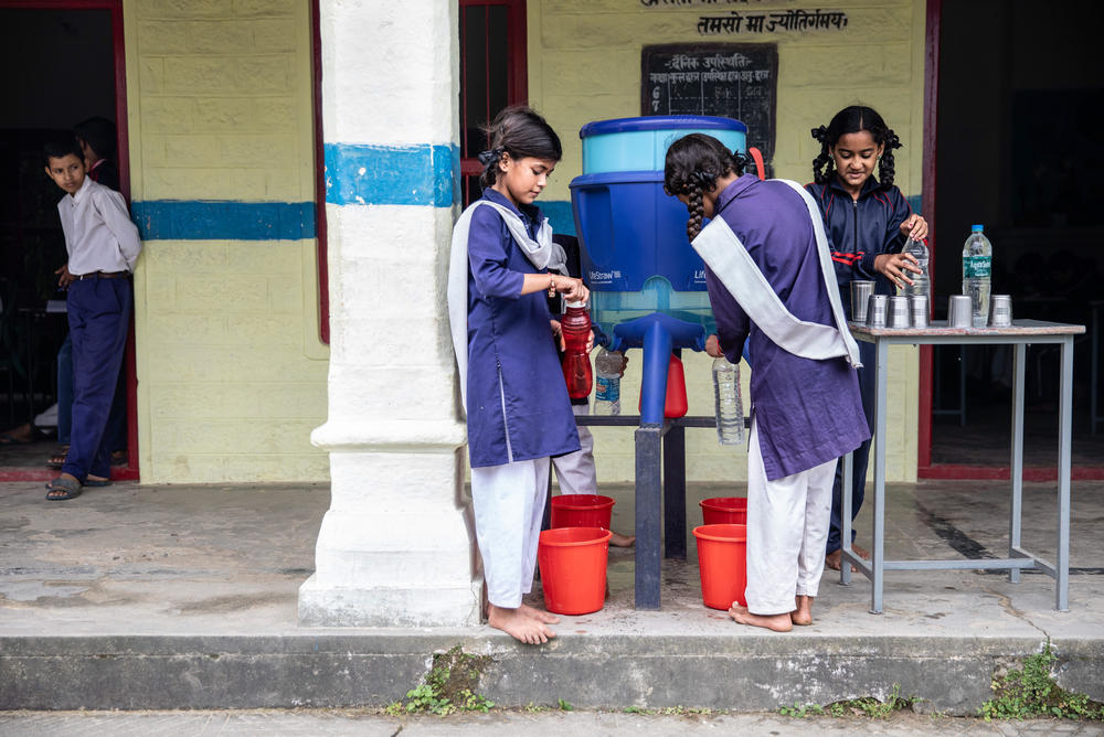 Students from the Okhaldunga village school fill their bottles with water that arrives via pipelines.