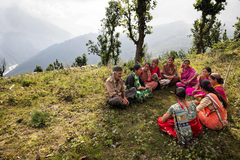 Members of the Rasuhil village water committee meet near their springs — and the pits they've dug so rainwater can accumulate and seep into the ground.