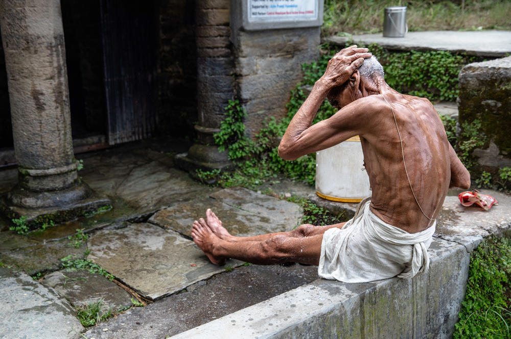 A village elder bathes at the village naula or spring in Kool village, Uttarakhand.