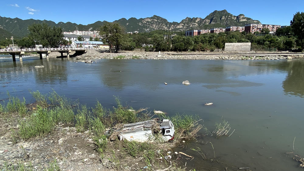 This summer, heavy rains hammered Beijing and the surrounding provinces. An overturned car on a riverbank is a testament to the seriousness of the deluge.