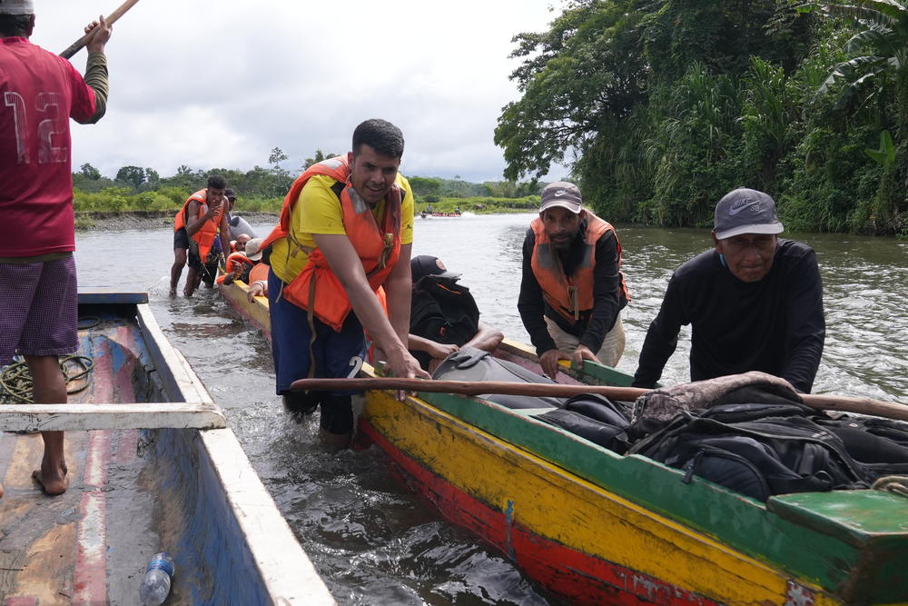 Migrants help to push a small motor boat past a shallow stretch of the Turquesa River, on Sept. 16. The boats take migrants from Bajo Chiquito to a government-run camp.
