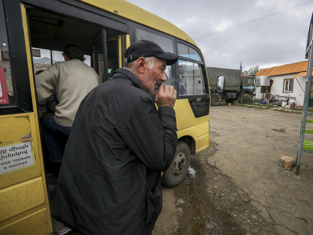 An ethnic Armenian man from Nagorno-Karabakh waits to get on a bus to Armenia's Goris, in Lissagorsk village, Azerbaijan, on Sunday. The last bus carrying ethnic Armenians from Nagorno-Karabakh has left the region.