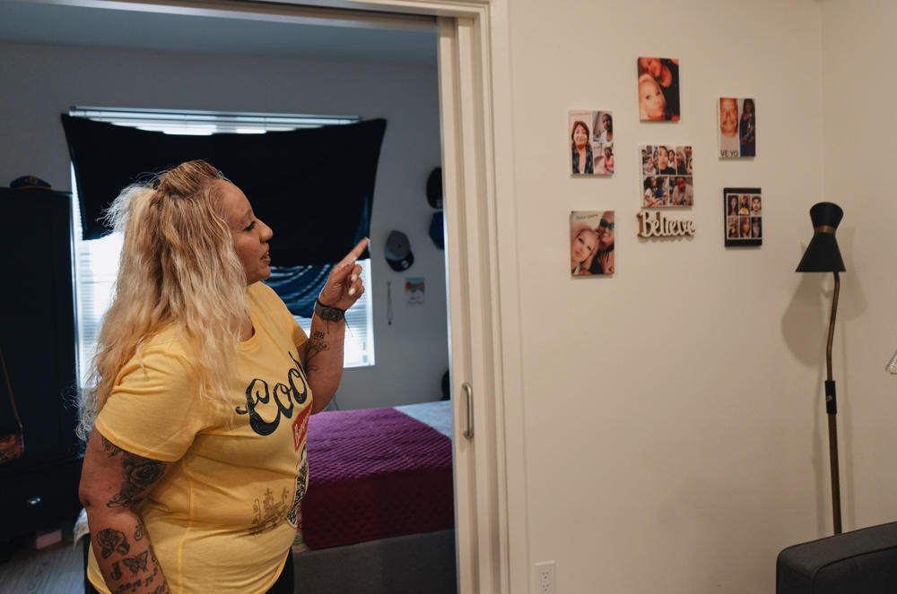 Valarie Zayas points out photos of family in their apartment in Los Angeles.