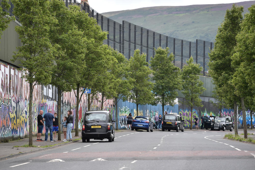 Tourists are given black taxi tours along the peace wall on Cupar Way in Belfast.