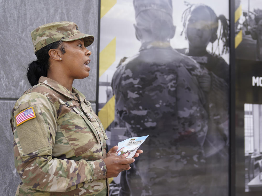 U.S. Army National Guard member Sgt. Jessica Jones, an officer with the Metropolitan Police Department, distributes brochures to people walking by during training in April, 2022 in Washington.