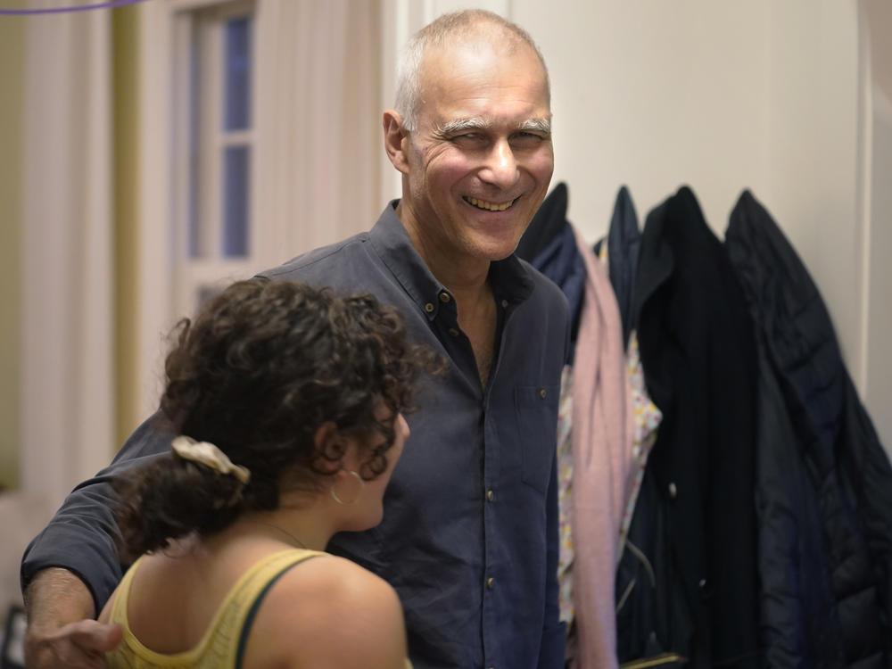 Moungi Bawendi of MIT, one of the 2023 winners of the chemistry Nobel Prize, embraces his step-daughter Julia Teller (left) at their home in Cambridge, Mass.