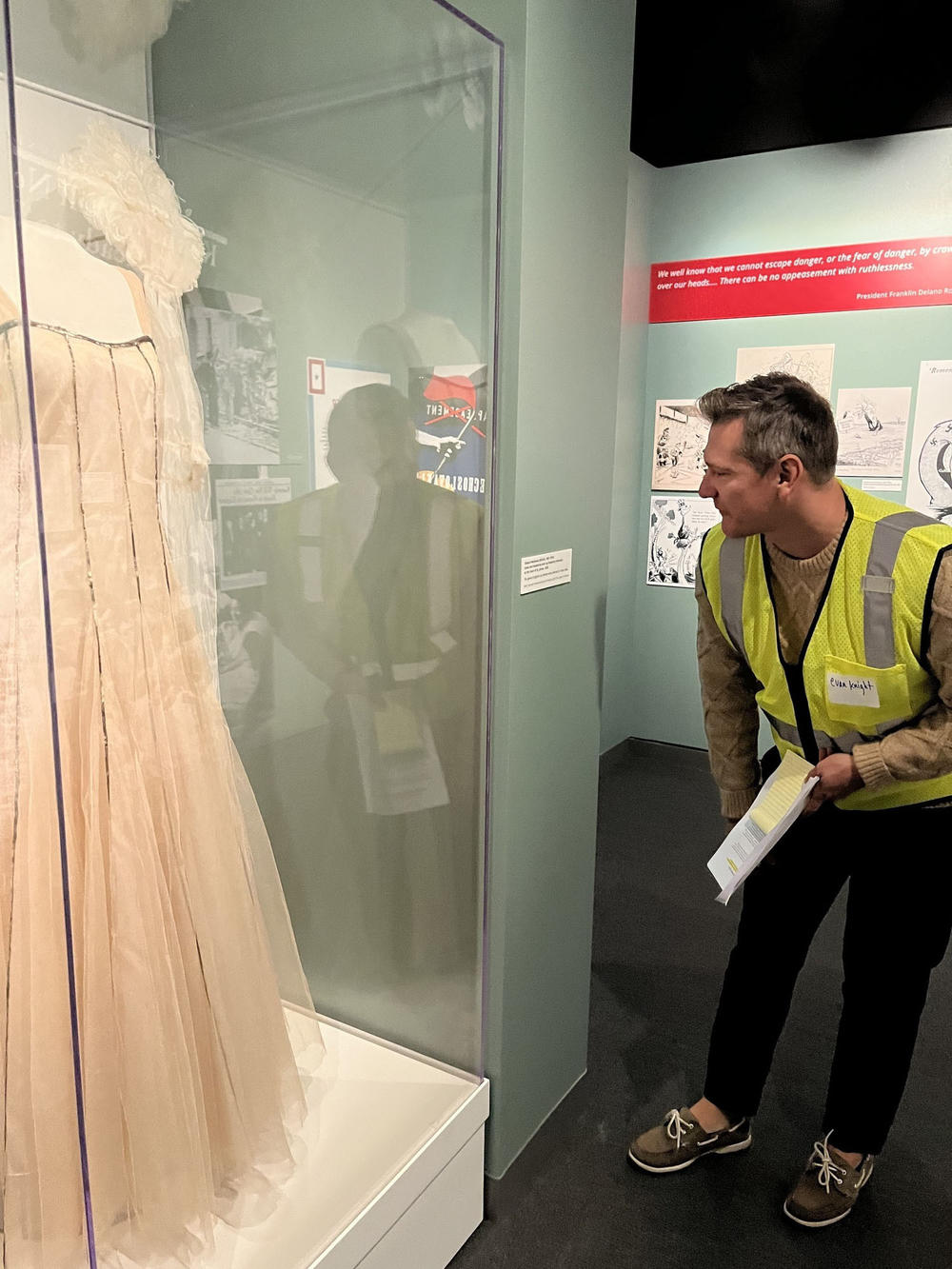 Disaster response training participant Evan Knight peers into a display case containing a ballgown worn by Rosemary Kennedy in 1938.
