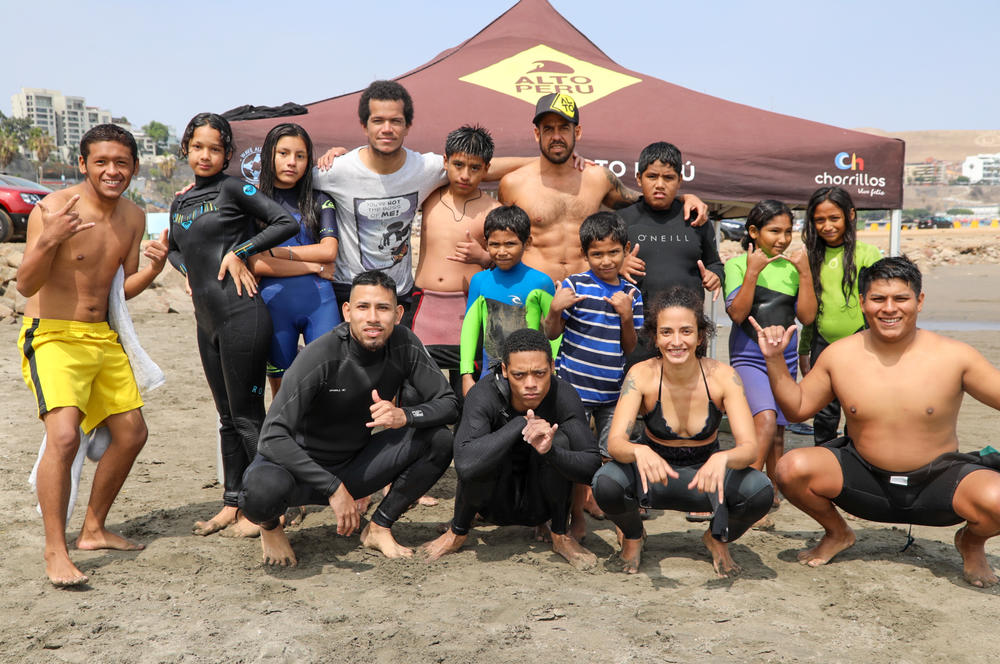 Surf instructors and kids on Playa Sombrillas beach in Lima.