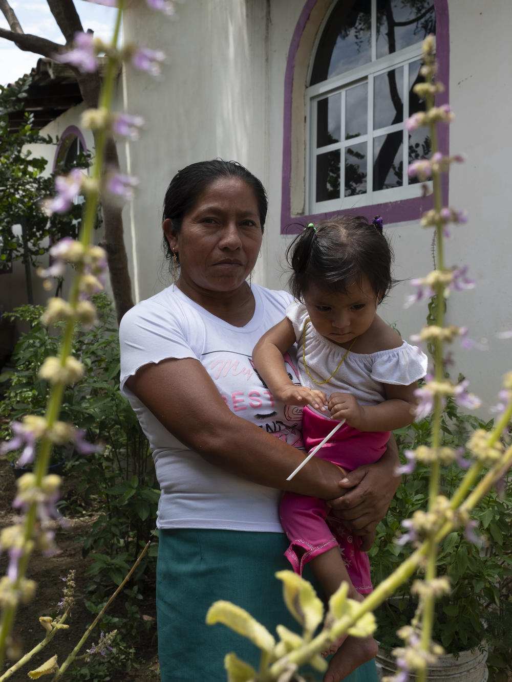 Paula Cano, a traditional midwife, holds her youngest child, who suffers a disability in her motor system. Paula thinks her daughter's disability is a result of her cesarean birth and because she wasn't allowed to keep the placenta to conduct the proper rituals.