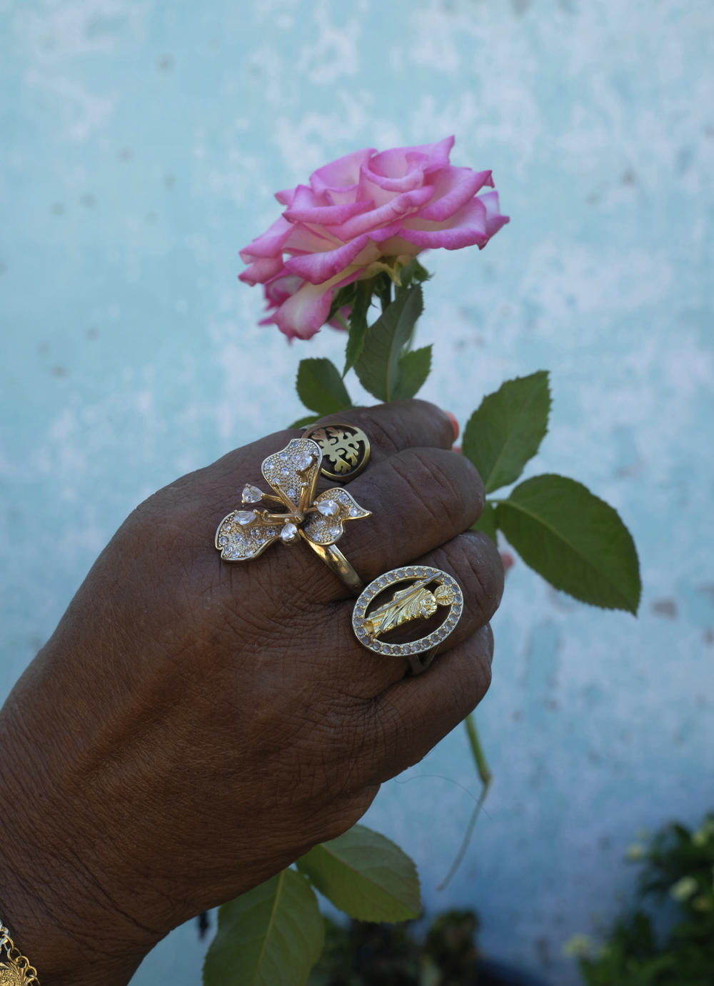 Tomasa holding a rose from her garden.